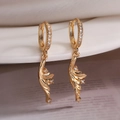 Gros plan de boucles d'oreilles feuilles de ginkgo dorées avec incrustations de zircon - Plume Dorée