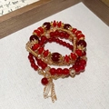 Detailed macro of red crystal beads and golden floral spacers on multilayered bracelet - Red (4-Piece Set)