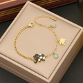 Detail of gold chain bracelet featuring black elephant charms and blue beads on a gift box - 5# Elephant