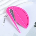 Close-up of pink plastic letter opener and hair elastic cutter tool on a white background - Pink