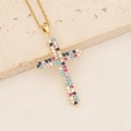 Close-up of 18K gold plated cross necklace with colorful zircons on a stone slab - Blue Pink and White Gemstone Cross (3#)