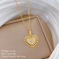 Detailaufnahme eines goldenen Herzanhängers mit Kristallen auf einem beigen Lederständer - Goldherz-Stil (H153)