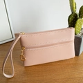 Pale pink faux leather wristlet with dual zipper compartments and gold heart pendant - Pink