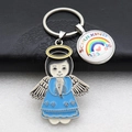 Detail of metal angel keychain with blue dress and rainbow pendant showing Schulkind text - Teal