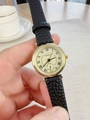 Close-up of classic Roman numeral dial and gold-tone case on black leather strap watch - Black Strap Gold Dial