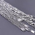 Vista macro di catene in argento 925 con chiusure a moschettone e targhette incise S925 - Argento 925 / Argento