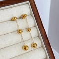 Detailansicht der 18K vergoldeten Ohrhänger mit drei Kugeln in einer Schmuckschatulle - Gold