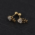 Macro shot of gold fishbone cartilage stud earrings with white zircon stones and screw balls - Fishbone - Gold