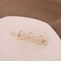 Dettaglio di un fermaglio per capelli dorato a cuore con perle su vassoio decorativo - Stile Perla Dorata