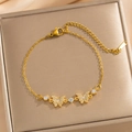 Elegante bracciale placcato oro con fiocco e zirconi su una scatola di gioielli - Oro