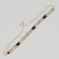 Détail d'un bracelet de perles fait main avec des perles géométriques noires et dorées et fermoir - Noir Or Argent Turquoise Tissé