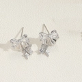Dettaglio di orecchini a fiocco in argento con ciondoli a stella e zirconi trasparenti - Fiocco a Cuore in Zircone Bianco Argento