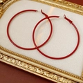 Makroansicht glänzend weinroter runder Kreolen auf einem eleganten Samt-Schmuckkissen - Silbernadel - Rot (Durchmesser 60mm)