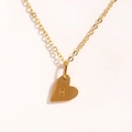 Détail macro du pendentif cœur avec lettre H gravée en finition dorée et polie - Lettre H