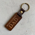 Detail of wooden keychain with WORLD'S BEST DAD engraving and brown leather strap - World's Best Dad / Brown