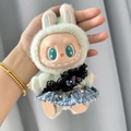 Labubu doll in green rabbit ear hoodie and denim skirt from The Monsters series - Black Feather Kiss / First And Second Generation Keychains Are Compatible With La Cloth Dolls. Dolls Not Included.
