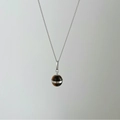 Detail shot of a tiger eye spherical pendant with a polished silver chain necklace - Silver Necklace (DDP005)