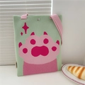 Close-up of mint green knitted tote bag with pink cat paw pattern and snap button closure - Cat Paw Green