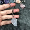 Handheld view of natural raw white crystal keychain with silver metal ring and chain - White Crystal