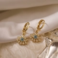 Gold plated evil eye hoop earrings with blue zircon insets on white silk fabric - Evil Eye Earrings