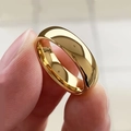 Polished gold minimalist round band ring with glossy finish held by fingers - US 7 / Gold