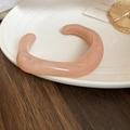 Close-up of pink acrylic bangle with white marble texture on ceramic plate - Pink Marble Pattern