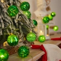 Catena di luci a sfere verdi strutturate con luce calda per decorazioni natalizie - 1,5m 10-LED Alimentato a Batteria / Sfera Verde Galvanizzata di Natale