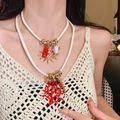 Double-layered marine necklace with red coral and fish charms on white leather cord - Gold White Marine Life Two-piece Necklace
