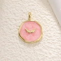 Detailed macro view of gold-rimmed pink glitter enamel pendant with golden wings - Wing