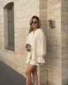 Detail eines cremefarbenen Crinkle-Sets mit Langarmhemd und Shorts mit Volantsaum - S / Aprikose