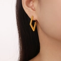 Elegante geometrische ruitvormige goud-titanium oorbellen gedragen door model - Ruit Stijl (Goud)