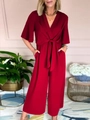 Dettaglio di tuta rosso scuro con scollo a V, cintura in vita e tasche laterali - S / Rosso