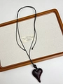 Macro view of a dark ebony wood heart pendant necklace on a natural wooden tray - Dark Wood Heart (XL1377B)