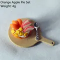 Macro detail of dollhouse fruit pie with mango and apple on a tiny wooden tray - Orange Apple Pie
