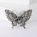 Dettaglio spilla a farfalla vintage in argento con strass grigi su espositore bianco - Nero