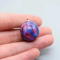 Macro-opname van een galaxy-stijl hars bolhanger met blauwe en paarse wervelingen - Paars