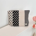Detailed close-up of a black and white polka dot canvas storage bag with Sozakka brand label - Black Vertical Polka Dot