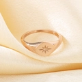 Macro detail of rose gold octagram star ring on luxury warm yellow satin fabric - Rose Gold