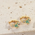 Goldene Hamsa-Creolen mit blauer Emaille und Zirkon-Steinen in der 45-Grad-Perspektive - Seeblau