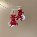 Dettaglio delle perline di corallo rosso e dischi di conchiglia su orecchini dorati - Stile Conchiglia Corallo Rosso