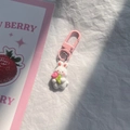 Detalle del llavero de conejo rosa con flor y cierre metálico sobre fondo blanco liso - Conejo Flor