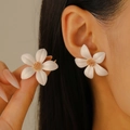 Minimalistische doppellagige weiße Blumenohrstecker mit Goldmitte am Model - KC Gold 10403 (Mattweiß)