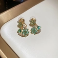 Detailed close-up of 18k gold flower earrings with green stones and sparkling crystals - Ear Clip-Blue