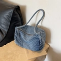 Blue washed denim shoulder bag with quilted stripe design on a minimalist stone pedestal - Light Blue
