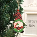 Detail eines Weihnachtsgnom-Holzanhängers mit rot-karierter Mütze an einem Baumzweig - Rote Weihnachtssocke Stil