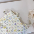 Detail of floral canvas tote bag featuring a woven label and colorful flower pattern - Scalloped Blue Purple Floral