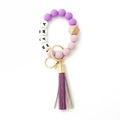 Detailed macro of MAMA silicone bead keychain with purple fringe and natural wood bead - Purple