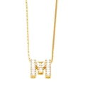 Close-up of golden letter M pendant with rectangular zircon stones on box chain - Gold M
