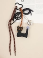 Detailed macro shot of a brown braided cord with black fabric cat and silver heart pendant - Bell Cat Style