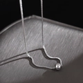 Macro detail of a silver box chain necklace with a polished sphere pendant - Steel Color Box Chain + Beads